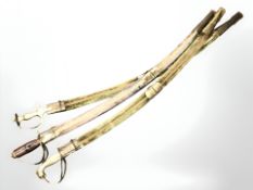 Three Indian swords with brass hilts.