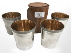 A set of four silver plated stirrup cups with gilded interiors, in stitched leather case.