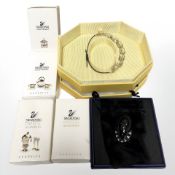 A group of Swarovski crystal classic miniatures, a bracelet and a pin badge.