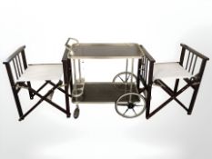 A pair of folding director's chairs and a metal trolley.