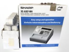 A Sharp XE-A107-WH cash register, boxed, together with a quantity of till rolls.