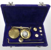 A set of brass sovereign scales in case, with weights.