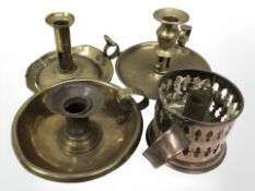 Three antique brass chamber sticks together with a further copper candle holder.