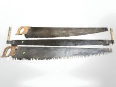 Three vintage twin-handled saws, length 148 cm.