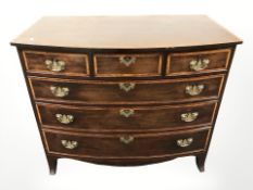 An early 19th century inlaid mahogany bow front chest of six drawers,