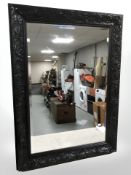 A contemporary black framed ornate mirror,