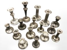 A collection of silver candlesticks including some pairs.