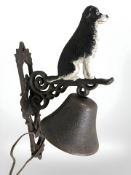 A cast iron border collie bell on bracket.