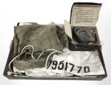 A World War II gas mask together with canvas bags.