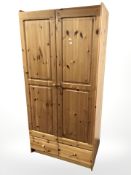 A pine wardrobe, fitted with two drawers,