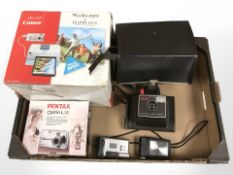 A group of cameras including Pentax, Canon Powershot camera, etc.