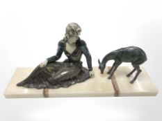 An Art Deco figure of a lady seated by a deer, on marble plinth, width 56 cm.