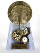 A crate containing barometer, brass plaque, Arts and Crafts brass charger, glass paraffin lamps,