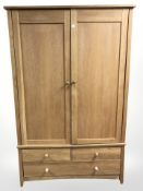 A contemporary light oak four-piece bedroom suite comprising a double- door wardrobe fitted with