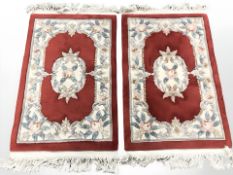 A pair of Chinese rugs on red ground,