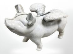 A cast figure of a flying pig.