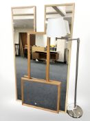 A group of contemporary mirrors and a standard lamp.