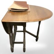A 20th century oak gate leg table together with four wheel back dining room chairs,