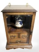 A late Victorian oak tobacco cabinet with glazed doors,