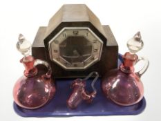 An Art Deco oak cased mantel clock, together with a pair of cranberry glass decanters and a basket.