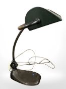 An antique copper banker's lamp with metal shade.