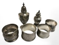 Four antique silver napkin rings, together with two silver pepper pots.