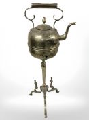 A brass kettle on three way stand.