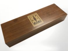 A wooden box containing playing cards and counters.