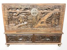An early 20th century carved camphor wood chest on stand, fitted two two drawers,