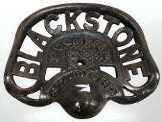 A reproduction black stone cast tractor seat.