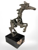 A modernist metal sculpture of a rearing horse, on ebonised plinth, height 25 cm.