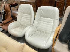 A pair of continental white stitched leather relaxer chairs on four-way steel supports