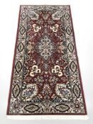 A machine made rug of Persian design, 187 cm x 92 cm.
