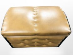 A tan vinyl storage footstool containing wool,