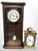 A reproduction wall clock and a brass mantel clock signed 'Angelique'.