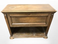 A continental oak fall front low cabinet on bun feet, 90 cm x 35 cm x 72 cm.