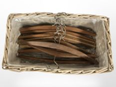 A basket containing 1970's Scandinavian teak coat hangers.