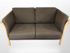 A contemporary beech framed two seater settee upholstered in grey fabric,