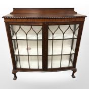 An early 20th century display cabinet on claw and ball feet,