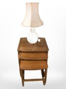 A nest of Nathan teak occasional tables, width 53 cm, together with a table lamp.