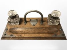 A Victorian oak and EPNS mounted desk stand with two glass ink wells, width 26 cm.