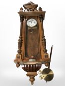 A 19th century stained beech wall clock, with weights and pendulum.