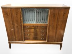 A mid 20th century walnut veneered display cabinet fitted four drawers,