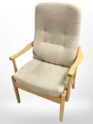 A contemporary beech armchair in oak meal coloured fabric,