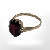 A 9ct yellow gold dress ring set with a synthetic garnet, size K.