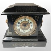 A late Victorian cast iron eight day mantel clock with enameled dial, height 27 cm.