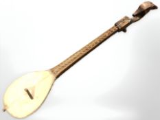 A continental carved wooden single stringed instrument,