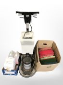 A Numatic International floor buffer with floor cleaning pads and cleaner.