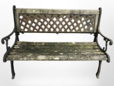 A weathered teak and cast iron garden bench,
