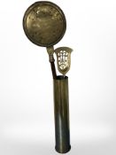 A large brass ammunition shell containing a brass bed warming pan and coal shovel